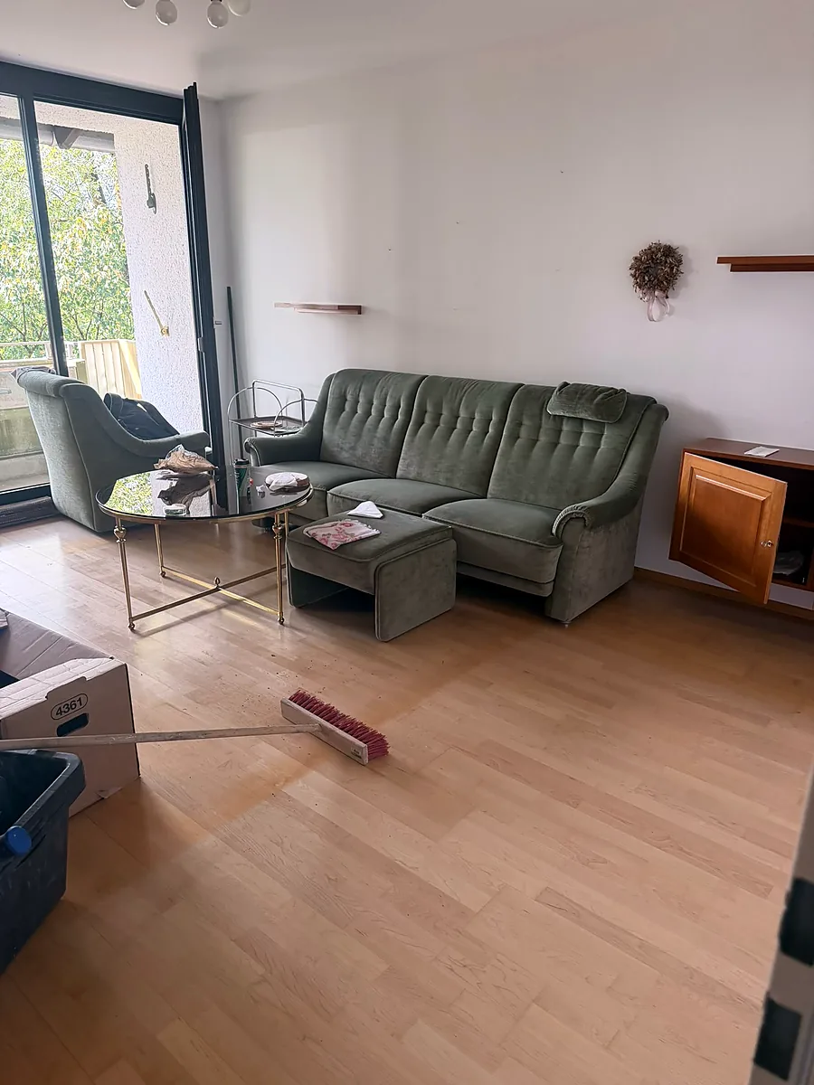 Wohnzimmer vor der Wohnungsauflösung mit Sofa und Möbeln